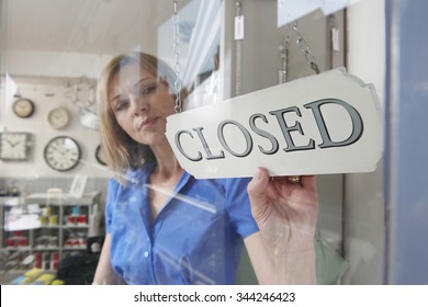 Store Owner Turning Closed Sign In Shop Doorway