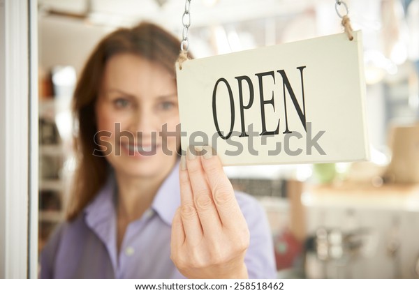 Store Owner\
Turning Open Sign In Shop\
Doorway