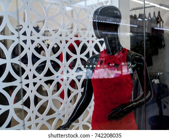 Store window with dressed mannequins in shopping mall. Full female red clothing. black female mannequin in a red dress