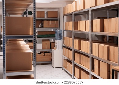 Storehouse interior with stacked cardboard boxes on tall metal racks. Goods cardboard boxes on shelves ready for transportration in industrial warehouse building with nobody inside