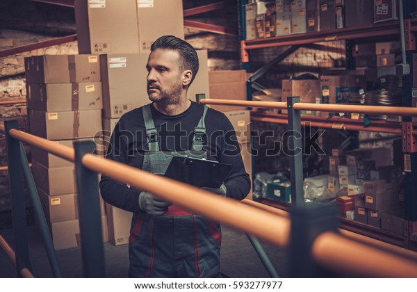 Storekeeper with\
manual picking list on a\
warehouse