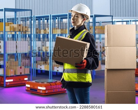 Storekeeper woman. Girl inside robotic warehouse. People and robots are working in storage. Robotic factory. Fulfillment processes. Woman storekeeper in yellow vest. Storekeeper career