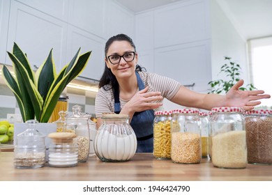 Storing food in kitchen, woman with jars and containers talking and looking at camera - Powered by Shutterstock