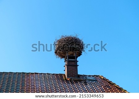 Stork nest on a chimney on a roof against a blue sky