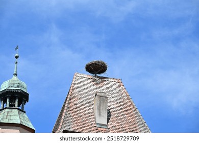 Stork nest on the Markusturm in Rothenburg ob der Tauber with patinated church tower under a blue sky in summer, Franconia, Bavaria, Germany - Powered by Shutterstock