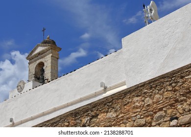 Stork nest at the top of the Neoclassical-1812 built Town Arch-Arco da Vila entrance in the Old Town's ramparts showing its whitewashed wall-a bell gable-a stopped clock. Faro city-Algarve-Portugal.