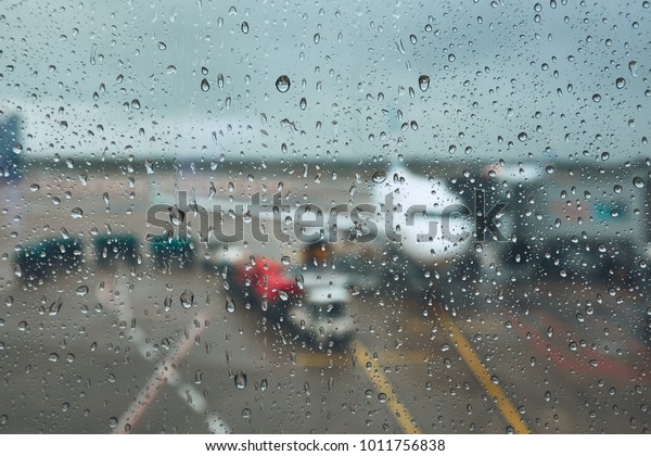 Storm at the\
airport. View of the airplane through rain drops. Themes weather\
and delay or canceled\
flight.