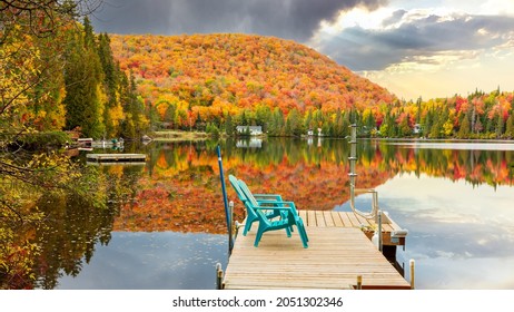 Storm arriving in cottage country with dock chairs empty, with fall colors in full bloom, Lantier Quebec, Canada