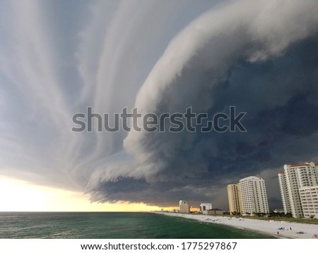 Storm cloud formation over the beach in Pensacola, Florida. Beautiful sunset with storm on the pier. Florida hurricane season, thunderstorm clouds.
