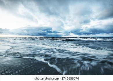 Storm Clouds Above The Baltic Sea In Winter, Long Exposure. Dramatic Sunset Sky, Waves And Water Splashes. Dark Seascape. Germany