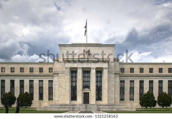 storm clouds behind the exterior of the federal\
reserve building