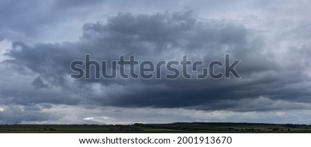 Storm clouds cover the landscape. Tragic gloomy sky. Panorama. Fantastic sky.