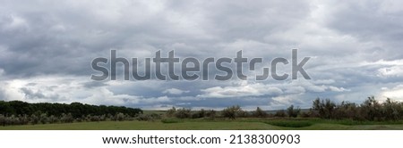 Storm clouds cover the landscape. Tragic gloomy sky. Panorama. 