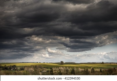 Storm clouds gathering over fields of yellow