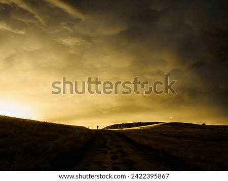 Storm clouds on sunset. Light in the dark and dramatic storm clouds. Background of storm clouds before a thunderstorm. Mammatus clouds