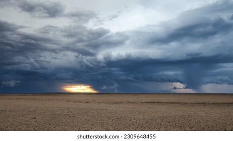 Storm clouds over a dry flat desert landscape