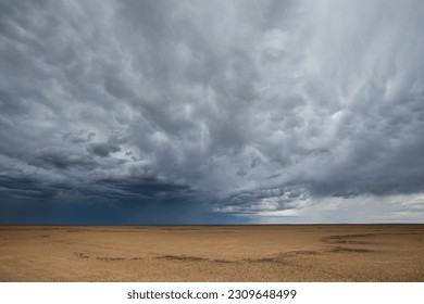 Storm clouds over a dry flat desert landscape - Powered by Shutterstock