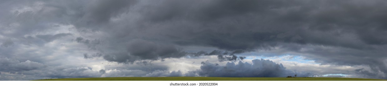 Storm clouds over the fields. Landscape at sunset. Tragic gloomy sky. Panorama. The sun is hidden. - Powered by Shutterstock