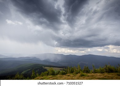 Storm Clouds Over The Mountains And Small Birds In A Dark Sky