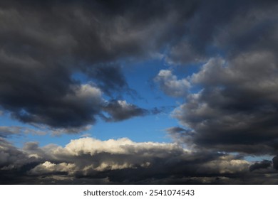 Storm cloudy dramatic sky with dark rain grey gray cumulus clouds and blue sky background texture, thunderstorm, heaven