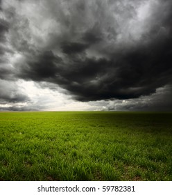 Storm Dark Clouds Flying Over Field With Green Grass