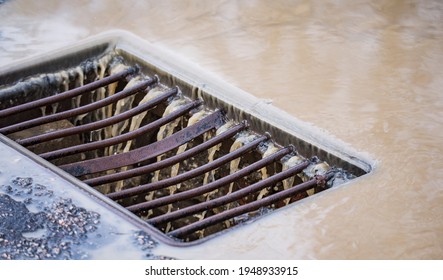 Storm Grate Close-up With Water Flowing Into It