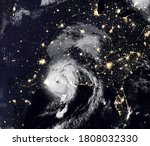 Storm Laura over USA at night, tropical hurricane eye from space. Typhoon landfall and city lights of Earth on satellite photo. Weather and warning concept. Elements of this image furnished by NASA.