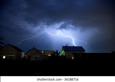 Storm And Lighting Over House. Thunderstorm At Night Near Village.