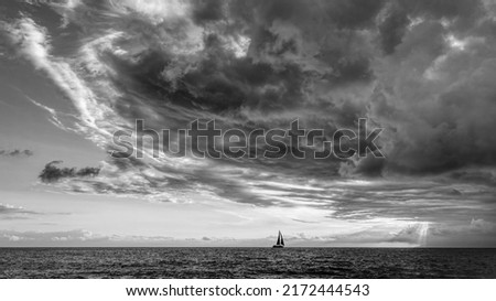 A Storm Is Looming Overhead As A Small Boat Moves Toward The Shining Light Black And White