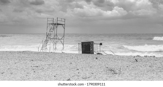 Storm On The Beach. The Fallen Tower Of The Rescuer. Black And White Grainy Photo With Soft Focus In Vintage Style.