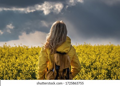 Storm and rain is coming. Hiking woman standing in rapeseed field and looking at cloudy sky. Tourist wearing yellow waterproof jacket

Jazyk pro klíčová slova: English