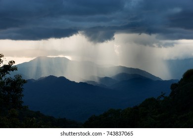 Storm Rain Is Falling Down In Mountain Range At Sunset In Tropical Rain Forest. 
Raining In Mountain .There Is Light And Hope At The End Of The Tunnel,positive Thinking Concept.
 