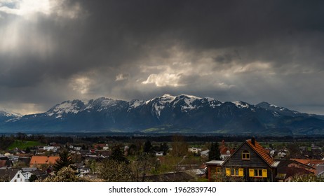 A storm rushes over the Rhine Valley, so that the peaks of the Alpstein massif disappear in the clouds. snowy mountains climb in the cloud. sun rays break through the clouds and illuminated snowy peak - Powered by Shutterstock