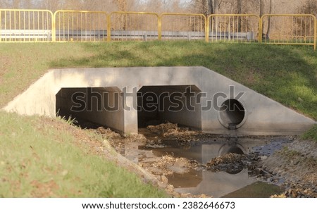 Storm sewer - a concrete culvert under the street.Storm sewer (and drainage) also called the 