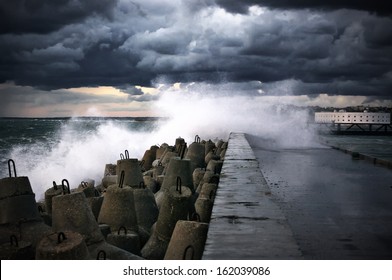 Storm Surf Breaking On Breakwater.