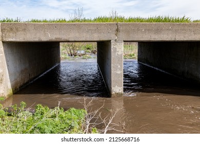 Storm Water Flowing Under Road Through Culvert Drain. Infrastructure, Flooding And Road Repair Concept.