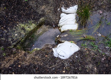 Stormwater Management, Inlet Pipe For Excess Rainwater, Sandbags, And Garden Plantings
