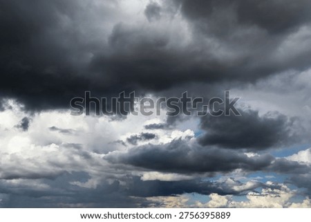 Stormy cloudy dramatic sky with dark rain thunderstorm cumulus clouds background texture