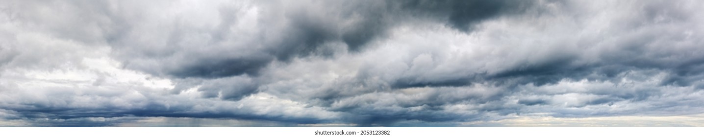Stormy cloudy sky wide panorama, dramatic dark blue thunderclouds, gale cloudscape, gray cumulus rain clouds panoramic view, thunderstorm heaven landscape, overcast cloudiness weather, hurricane skies