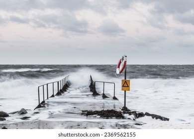 A stormy coastal scene with a wind-swept horizon over water. - Powered by Shutterstock