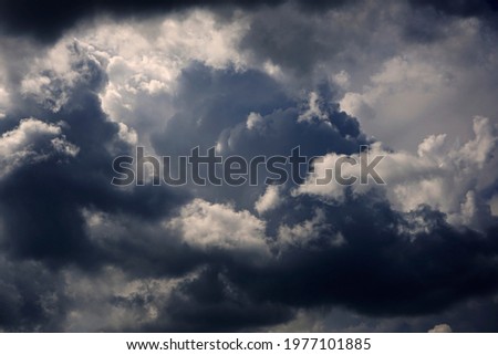  Stormy cumulus clouds view. Dramatic sky before a thunderstorm. Dark ominous low clouds. Cloudy gloomy sky background for design.                              