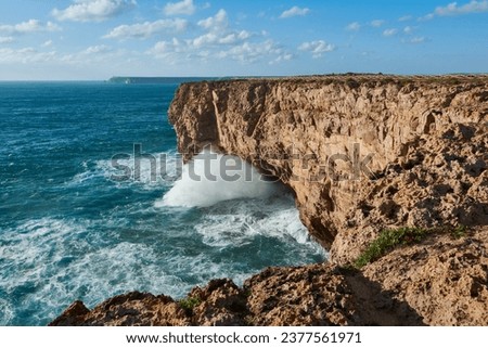 Stormy ocean with huge breaking waves washing the cliffs. Sagres Fortress in Portugal