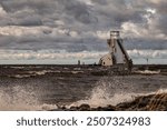 Stormy seashore, lighthouse and person watching storming water in Nallikari, Oulu