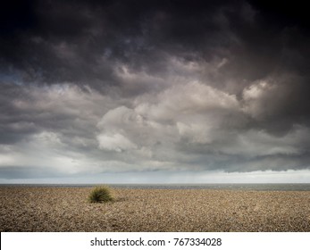 Stormy Skies Over A Shingle Beacn In Norfolk.