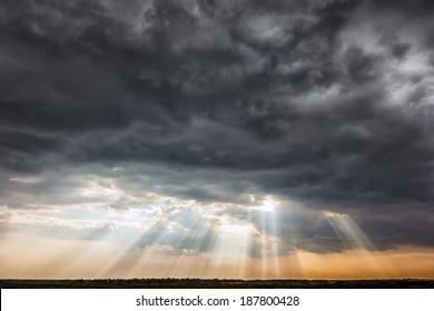 Stormy sky with a dramatic sunrays between the clouds on spring evening in Greece 