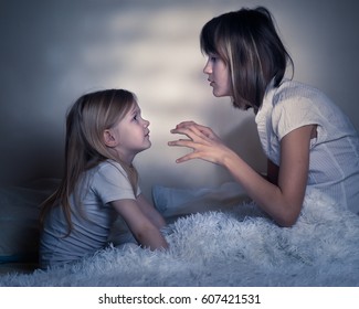 Story Before Bed. Older Sister Tells Younger Sister A Scary Story