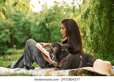 Story reading, red book. Young pretty woman is with her dog in the park. - Powered by Shutterstock