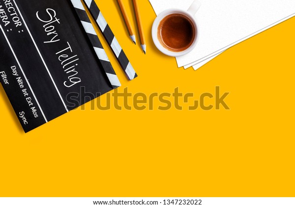 Story telling text title on movie clapper\
board  and coffee cup on yellow\
background
