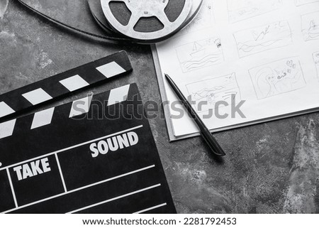Storyboard with movie clapper and film reel on dark background