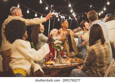 Storytelling footage of a multiethnic group of people dining on a rooftop. Family and friends make a reunion at home - Powered by Shutterstock